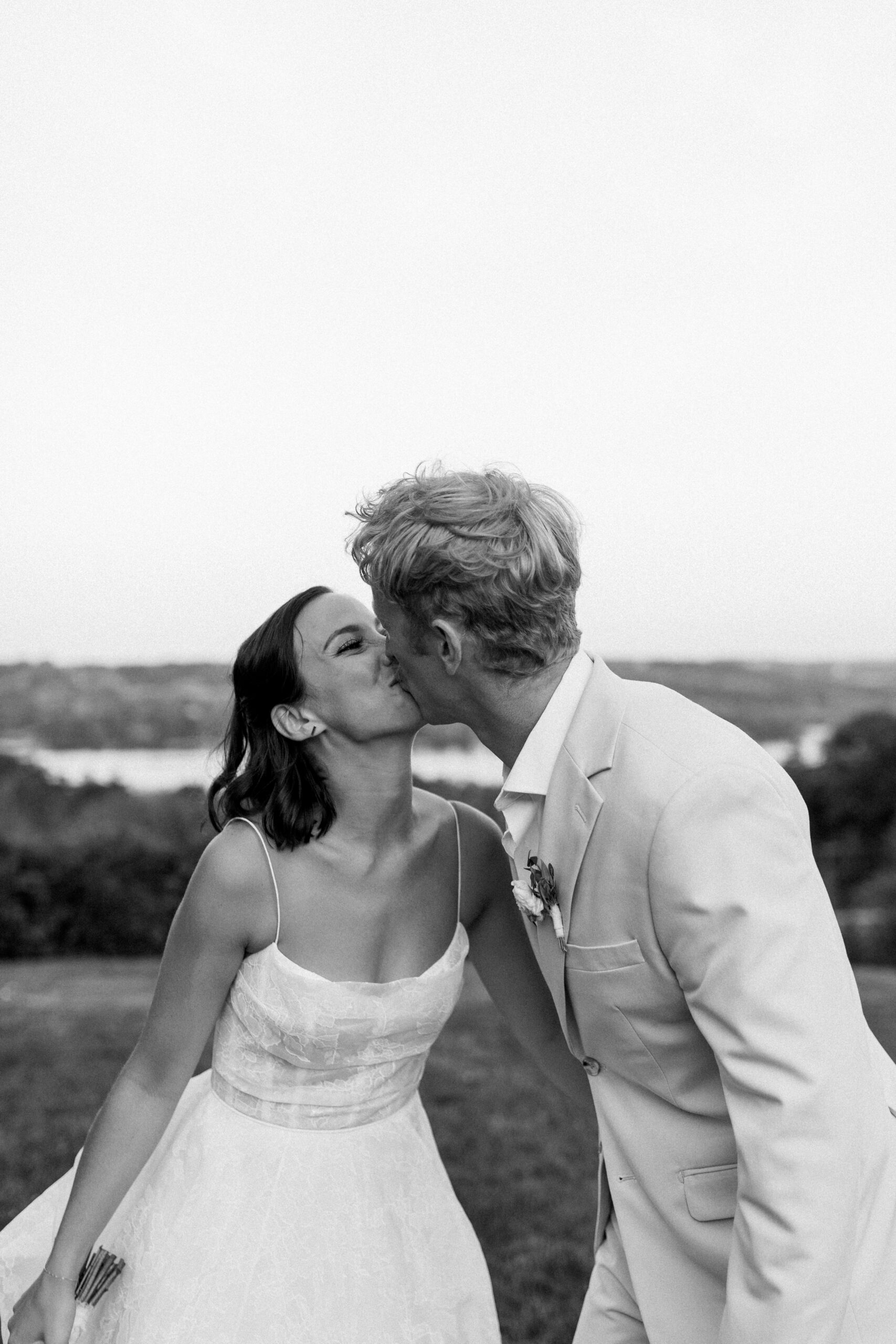 bride and groom kissing at their Crispin Hill wedding overlooking Keuka Lake