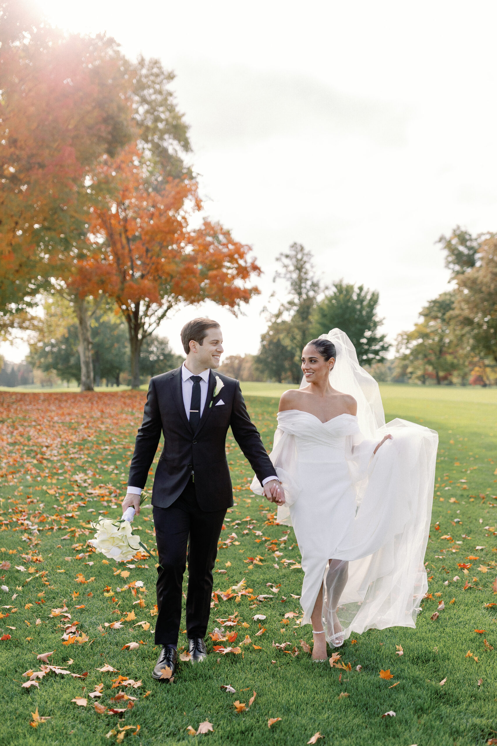 The couple holding hands and walking at Oak Hill Country Club